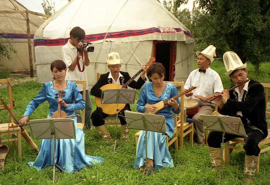 A scan from a 35mm photograph which I took at a yurt camp at Karakol in Kyrgyzstan in July 2002. The musicians are playing a selection of traditional Kyrgyz instruments, including komuz (stringed instrument in centre for. Фото: No machine-readable author provided. SiGarb assumed (based on copyright claims)., Public domain, Викисклад
