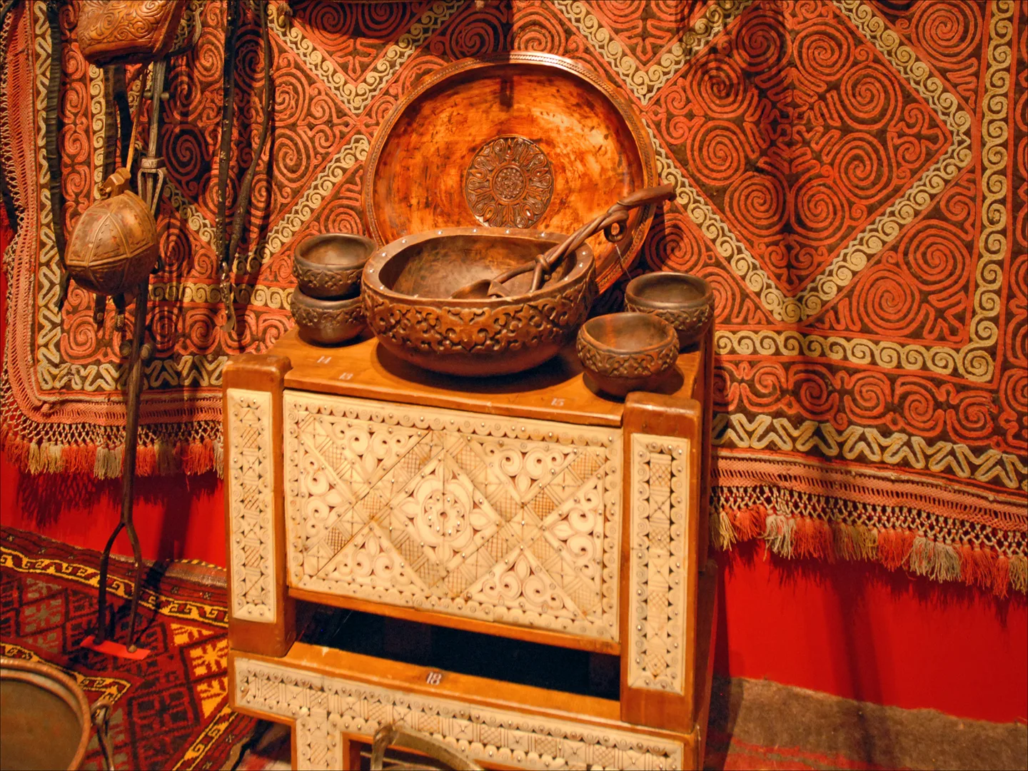 Reconstitution de l'intérieur d'une yourte Sur le coffre posé sur son socle : se trouve au centre un bol à kumys, (le kumys est une boisson faite de lait de jument fermenté) objet fait à Alma-Ata par le maître artisan G.. Фото: dalbera from Paris, France, CC BY 2.0, Викисклад